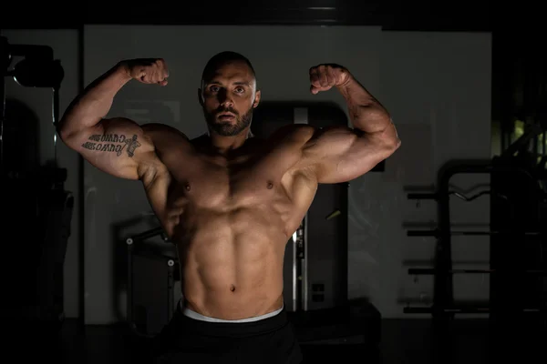 Athlete Muscular Bodybuilder Posing In The Gym