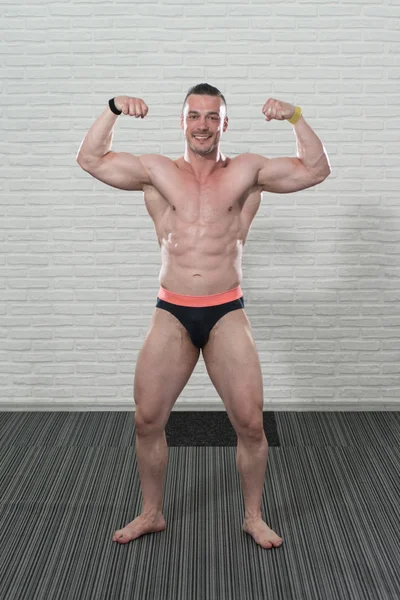 Bodybuilder Fitness Model Flexing Muscles