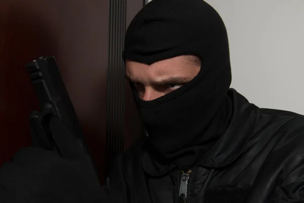 Burglar Standing Behind The Door With A Gun