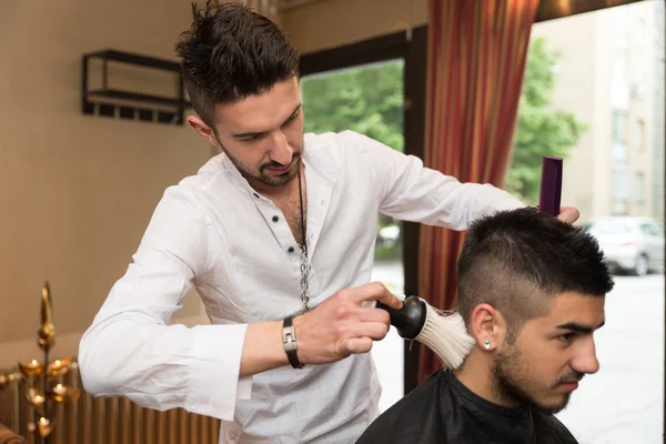Hairdresser Making Haircut To Young Man