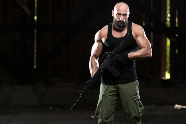 Muscular Man Holding Machine Gun