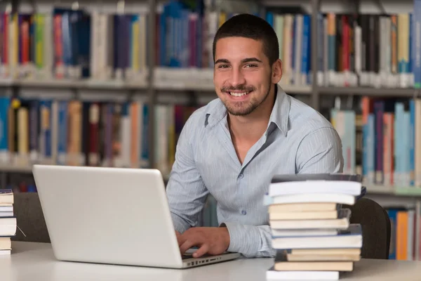 Happy Male Student With Laptop In Library