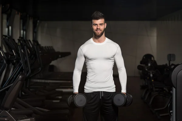 Young Man Exercising Biceps With Dumbbells