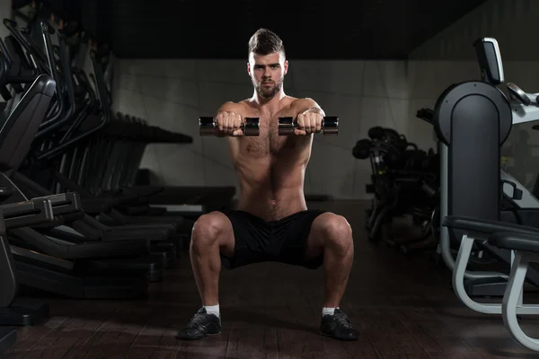 Young Man Doing Exercise Dumbbell Squat