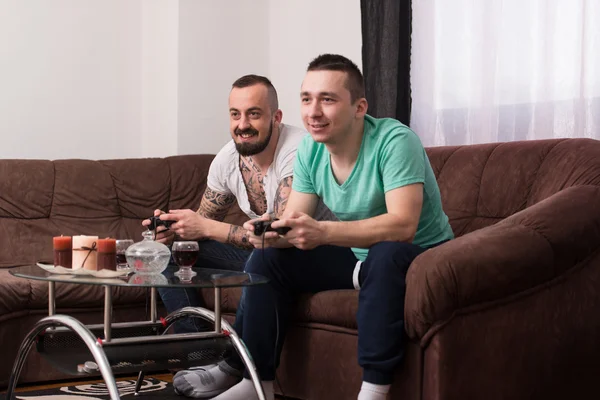 Smiling Male Friends Playing Video Games At Home
