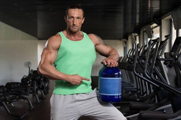 Bodybuilder Posing With Supplements For Copy Space