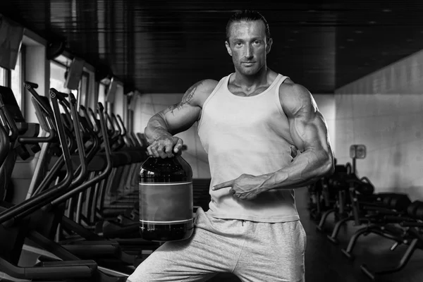 Bodybuilder Posing With Supplements For Copy Space