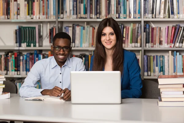 Happy Students Working With Laptop In Library