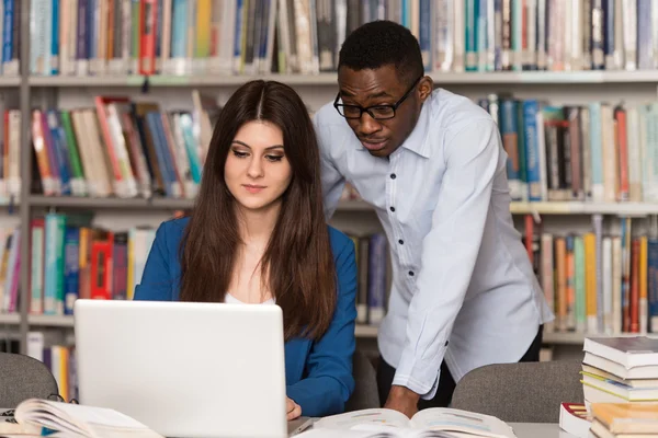 Happy Students Working With Laptop In Library