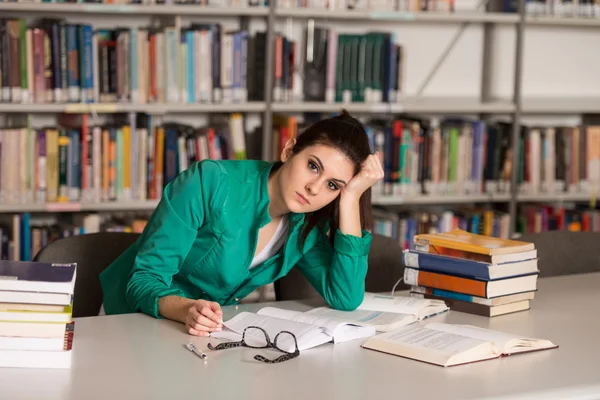 Confused Female Student Reading Many Books For Exam