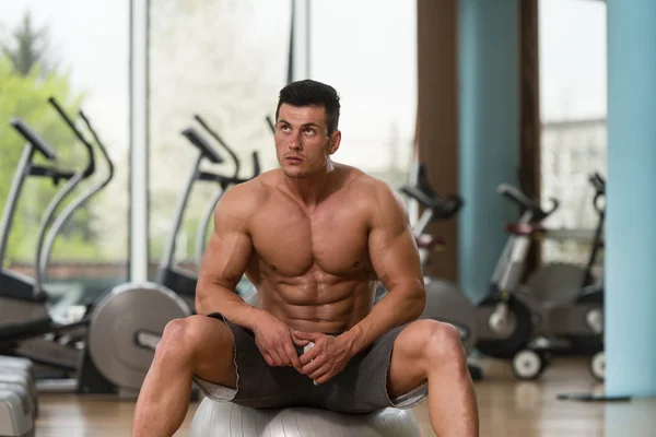 Portrait Of A Muscular Man Relaxing In Gym