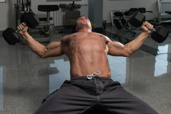 Muscular Man Doing Exercise For Chest With Dumbbells