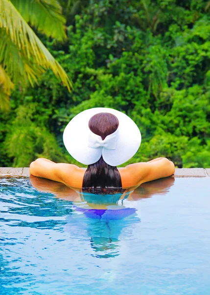 Woman in white hat in the swimming pool