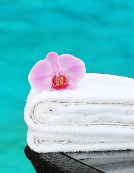 Clean towel with orchid poolside