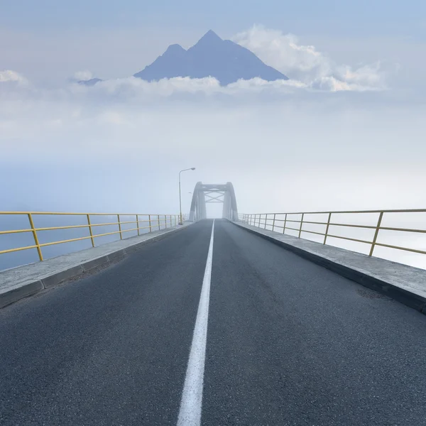 Driving on an empty mountain road across the bridge