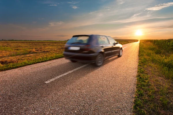 Black car in motion blur on open road