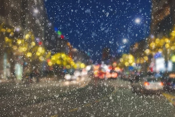 Snowing night on city streets