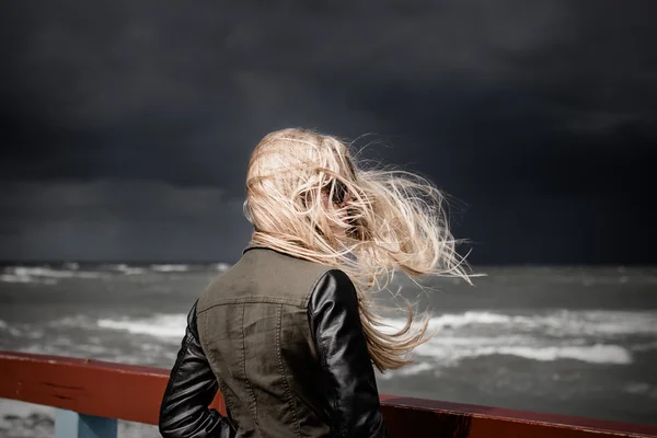 Girl looking at stormy sea