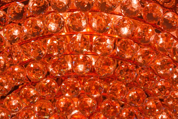 Closeup of a fire ruby crystal glass jewelry gem texture pattern background from a Chandelier