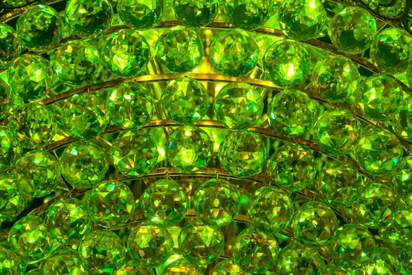 Closeup of a green emerald crystal glass jewelry gem texture pattern background from a Chandelier