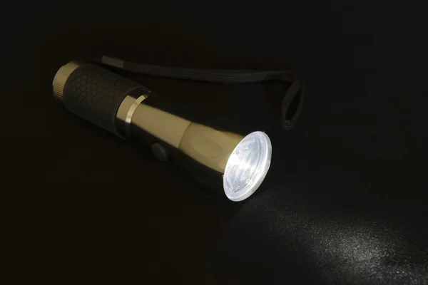 Included flashlight isolated on black background