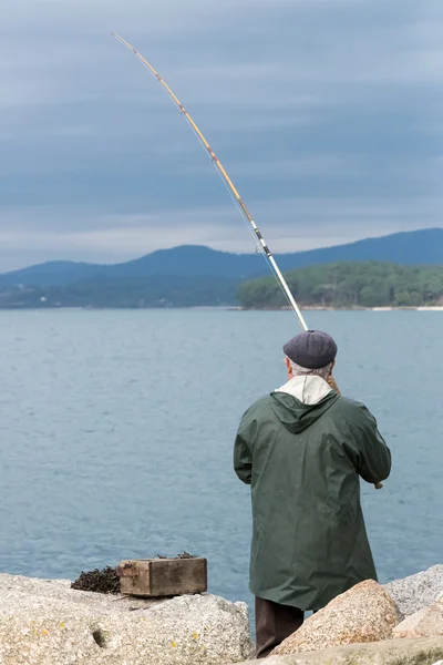 Elderly man fishing on the ocean