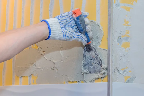 Construction work laying tile on the wall