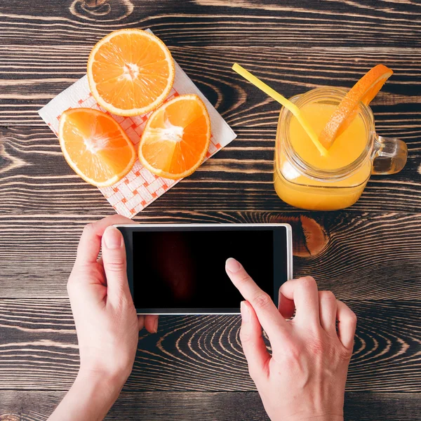 Woman Using Mobile Phone against Fruits Oranges. Technology Concept.
