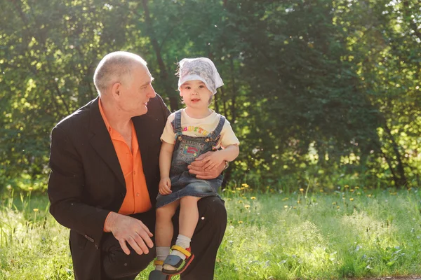 Grandfather and Granddaughter Outdoors Smiling