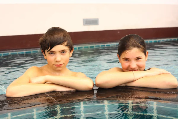 brother and sister portrait in the swimming pool