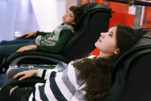 Teen siblings brother and sister in massage chair