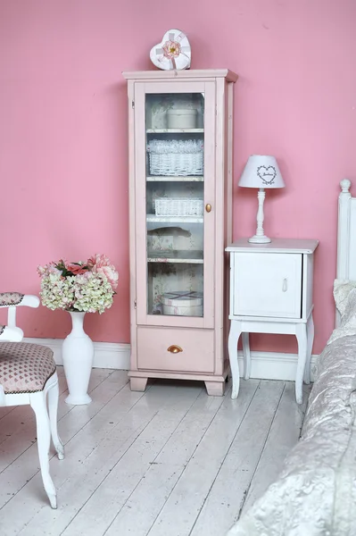 Cozy stylish vintage corner of the pink bedroom with floor vase
