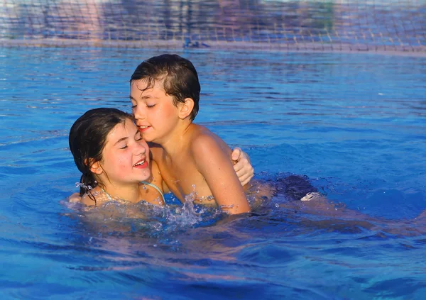 Siglings boy and girl play in open air swimming pool at the egyp