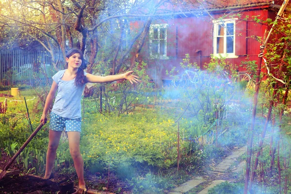 Beautiful teen girl in the fire smoke on the spring village back