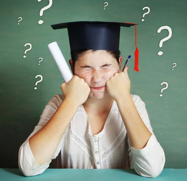 Girl in graduation cap try to solve many difficult questions