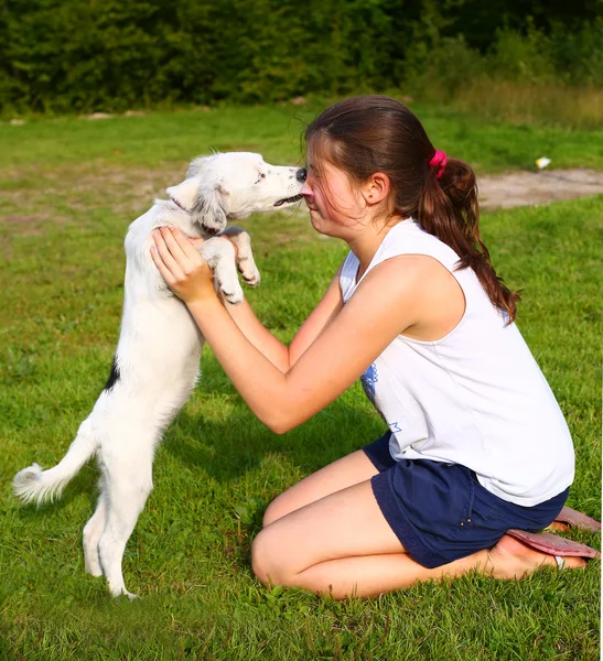 Girl with white puppy on the summer backgroune