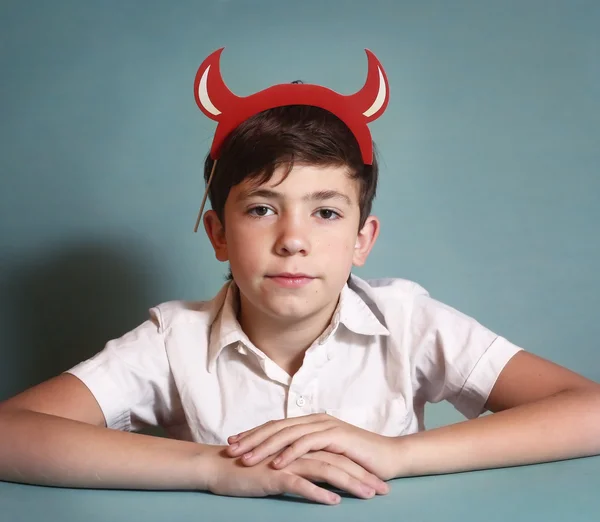 Boy in white shirt and red horns