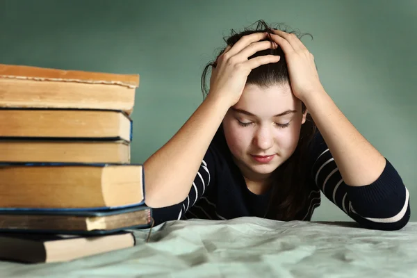 Tired teenage girl sleep among book