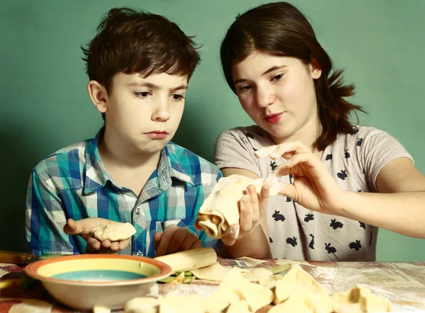 Sister teach brother boy how to bake apple pies