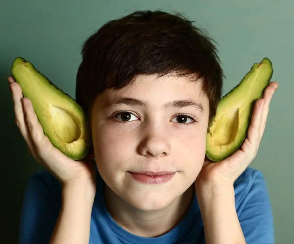 Cute preteen boy performing elf with avocado half