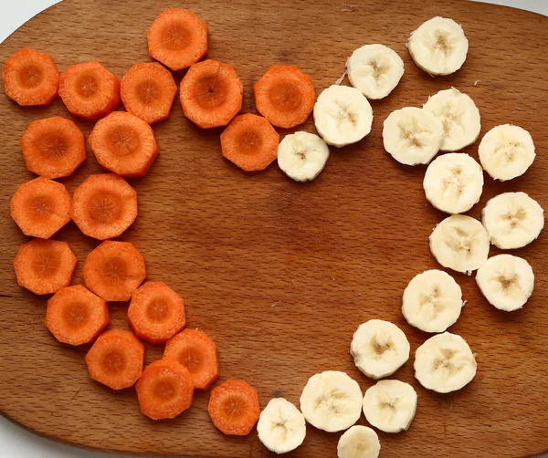 Cut carrot and banana circles forming heart