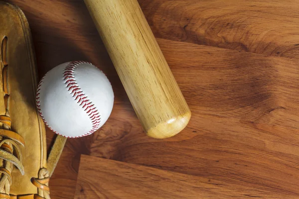 Baseball bat with ball and baseball glove on wood background