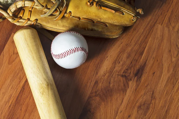 Baseball bat with ball and baseball glove on wood background