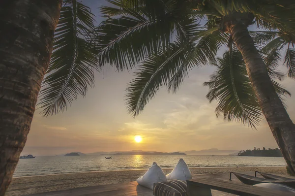 Views of sunrise with cushions and coconut palm trees on tropical beach background at Phayam island in Ranong province, Thailand