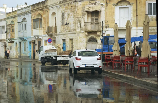 MARSAXLOKK, MALTA-dec 18: street in typical colorful maltese village Marsaxlokk on dec 18, 2015 on rainy cloudy day. Daily typical life in small Marsaxlokk village. Malta. Raining in Marsaxlokk, Malta