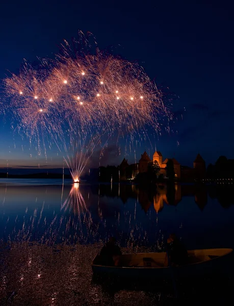 Fireworks in Trakai, Lithuania. Big colorful fireworks explode with nice reflection on a water, July, Independence, fireworks with old castle in the background