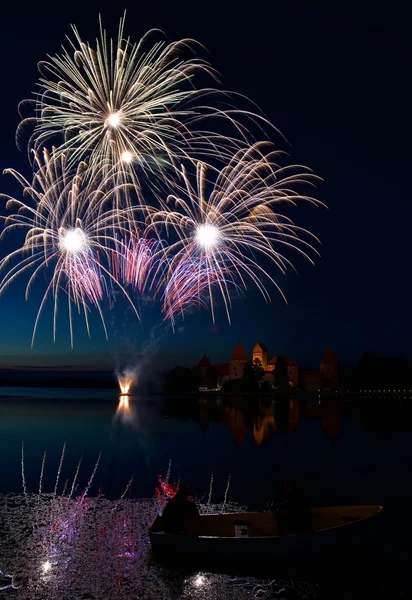 Big colorful fireworks explode with nice reflection on a water, July, Independence, fireworks with old castle in the background