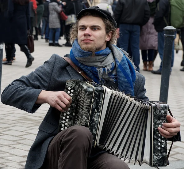Vilnius, Lithuania, March 4: young street musician playing in street musician even in Vilnius on March 4, 2015. Young unknown artist performing in the street. Musician passion