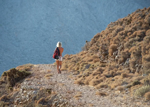 Unknown woman hiking in the mountains, Tilos landscape, Greece