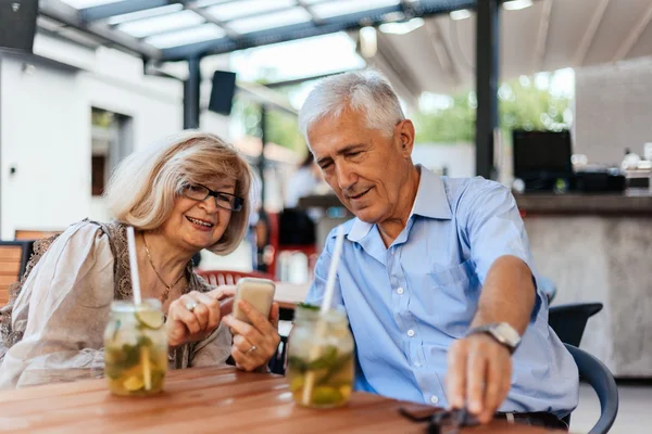 Mature Couple In Cafe Using Technology